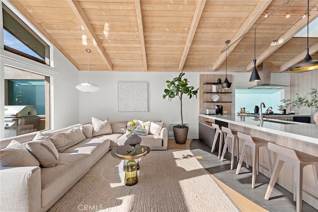 living room featuring lofted ceiling with beams, sink, and wood ceiling