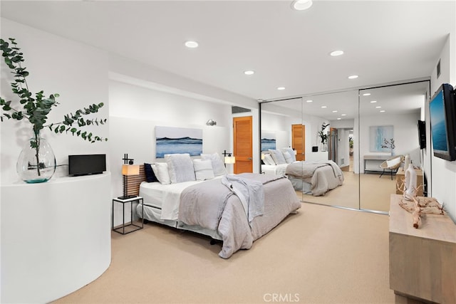 bedroom featuring light colored carpet and a closet