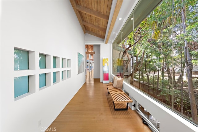 hallway featuring beamed ceiling, high vaulted ceiling, wood ceiling, and hardwood / wood-style floors