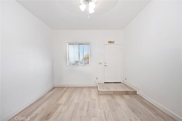 unfurnished room with a ceiling fan, baseboards, and light wood finished floors