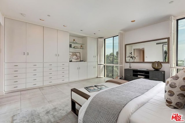 bedroom with floor to ceiling windows and light tile patterned floors