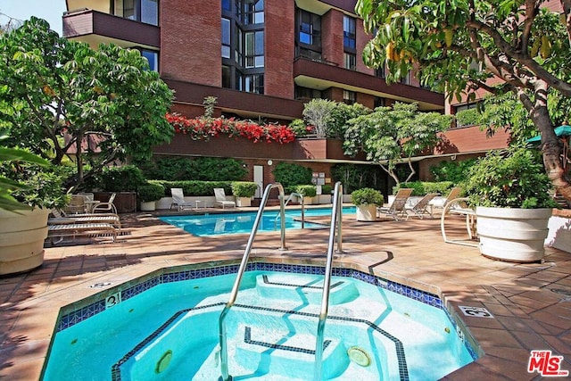 view of swimming pool with a community hot tub and a patio