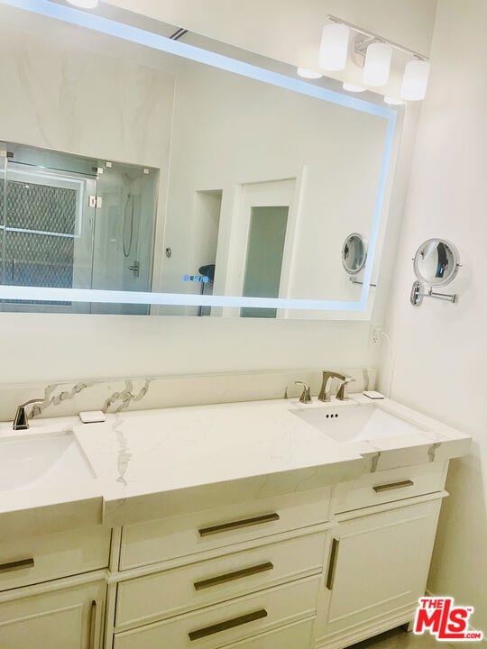 bathroom featuring walk in shower and vanity