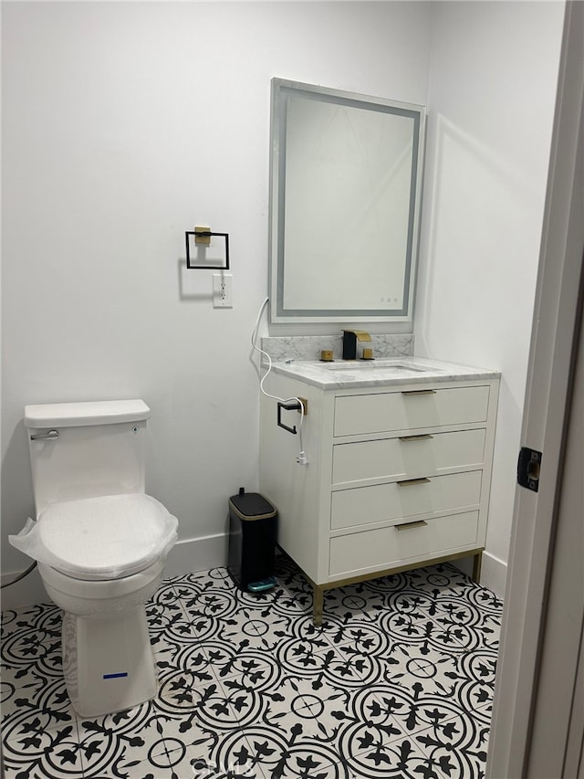 bathroom with tile patterned flooring, vanity, and toilet