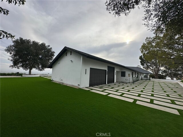 rear view of house with a garage and a yard