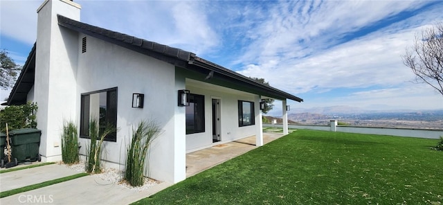 view of home's exterior featuring a water view and a yard