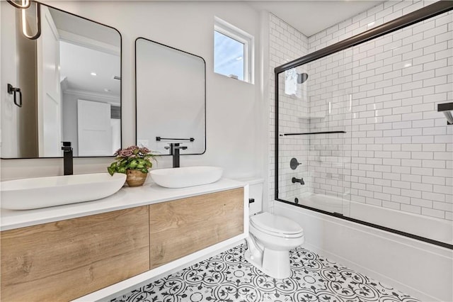 full bathroom with tile patterned flooring, vanity, shower / bath combination with glass door, and toilet