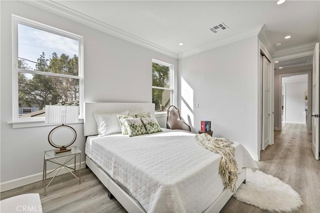 bedroom with ornamental molding and light wood-type flooring