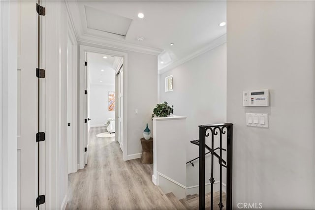 hallway with ornamental molding and light hardwood / wood-style floors