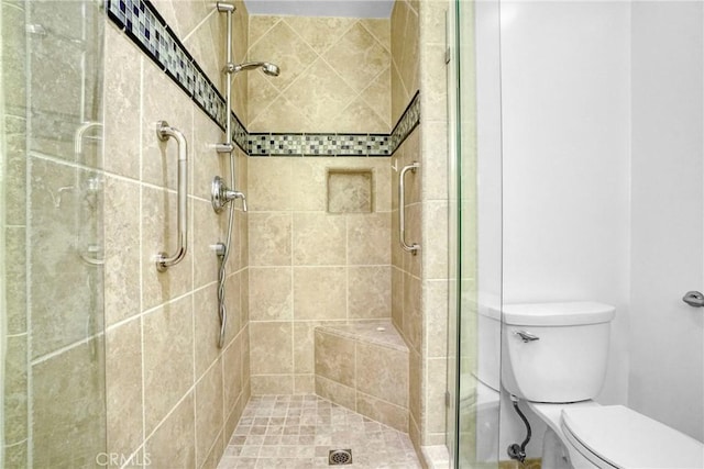 bathroom with toilet and a tile shower