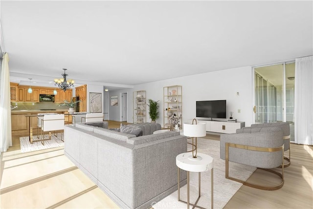 living room with an inviting chandelier and light hardwood / wood-style floors