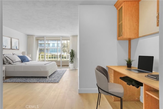 bedroom featuring light hardwood / wood-style floors and a textured ceiling