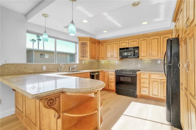 kitchen featuring pendant lighting, kitchen peninsula, decorative backsplash, and black appliances