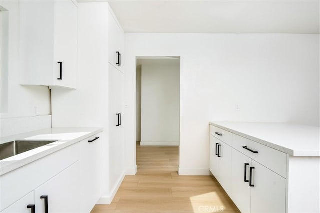 kitchen with white cabinetry and light hardwood / wood-style floors