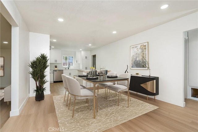 dining space with sink and light hardwood / wood-style flooring