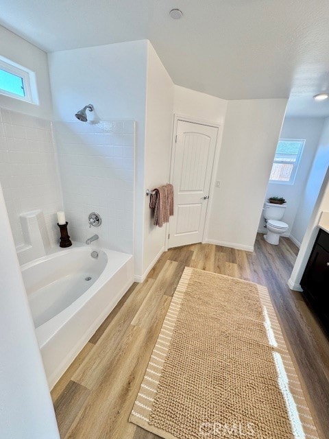 full bathroom featuring hardwood / wood-style flooring, shower / tub combination, vanity, and toilet