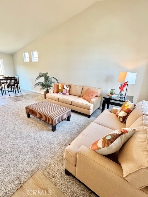 living room featuring high vaulted ceiling and carpet flooring