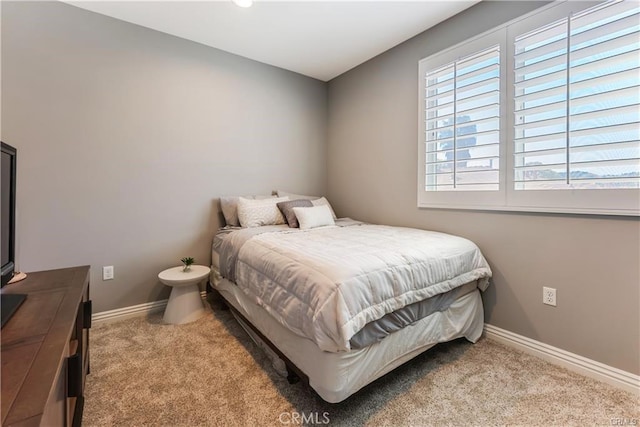 bedroom with baseboards and light colored carpet