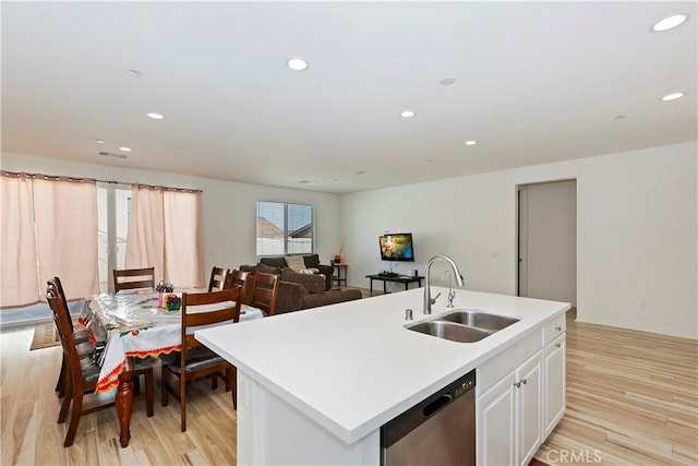 kitchen with sink, light hardwood / wood-style flooring, dishwasher, an island with sink, and white cabinets