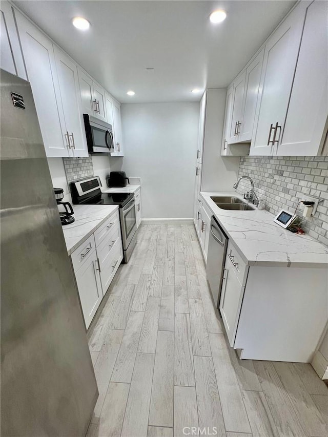 kitchen with stainless steel appliances, sink, and white cabinets