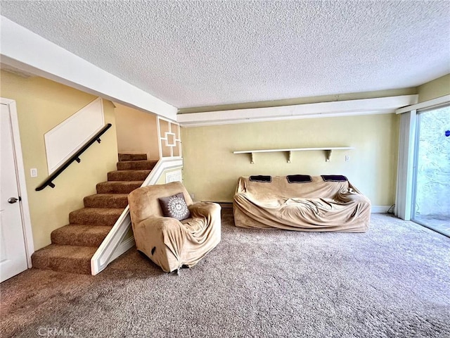 living area with carpet, stairway, and a textured ceiling