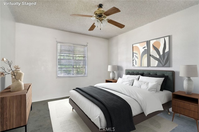 carpeted bedroom with ceiling fan and a textured ceiling