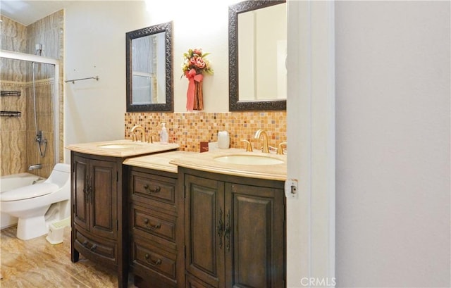 full bathroom with double vanity, toilet, backsplash, and a sink