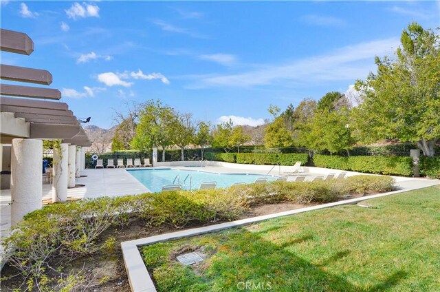 view of swimming pool with a mountain view, a yard, and a patio