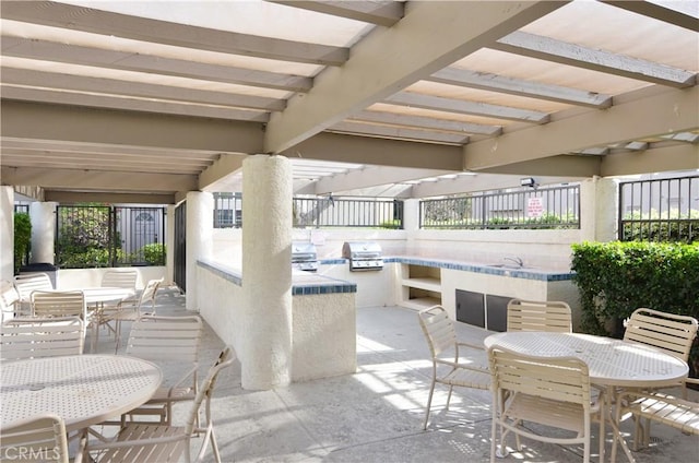 view of patio with an outdoor kitchen, outdoor dining space, grilling area, and a sink