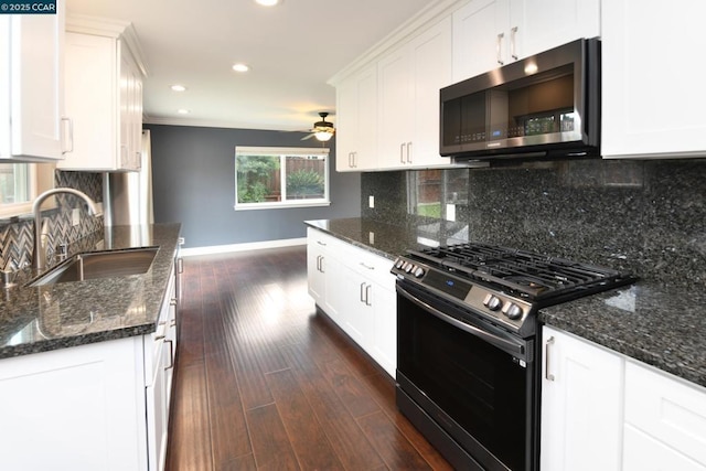 kitchen with stainless steel appliances, tasteful backsplash, sink, and white cabinets