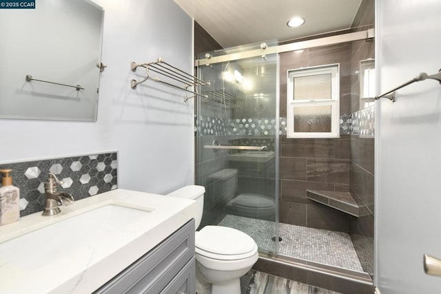 bathroom with a shower with door, vanity, tasteful backsplash, and toilet