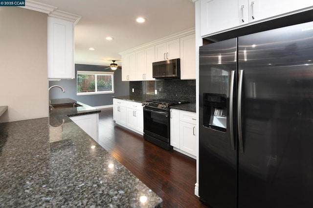 kitchen with sink, white cabinets, dark stone counters, stainless steel appliances, and dark wood-type flooring