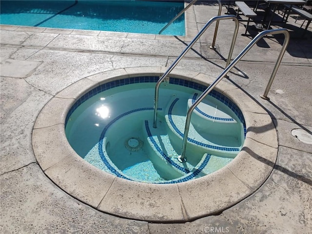 view of pool with an in ground hot tub and a swimming pool