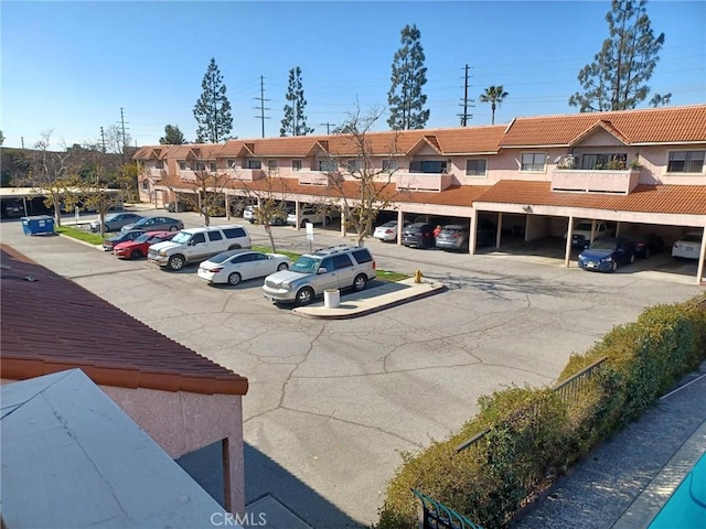 partially covered parking lot featuring a residential view