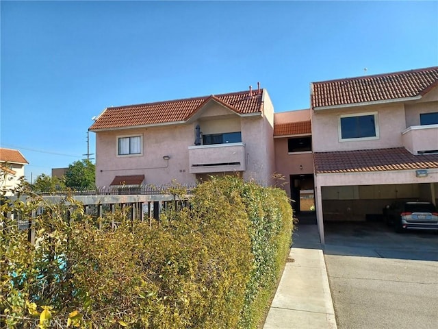 view of front of property with a tile roof, concrete driveway, and stucco siding