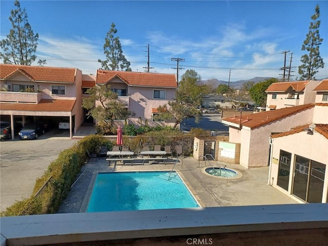 view of swimming pool featuring a hot tub and a patio