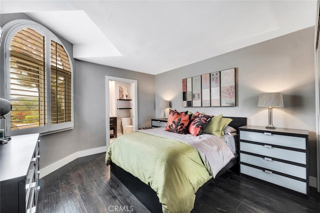 bedroom with ensuite bathroom and dark hardwood / wood-style flooring