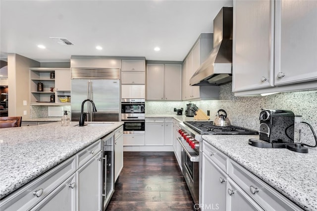 22544 N Summit Ridge Cir, Chatsworth, CA 91311 - kitchen featuring wall chimney range hood, premium appliances, dark wood-style flooring, light stone counters, and backsplash