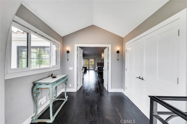 corridor featuring dark wood-type flooring and vaulted ceiling