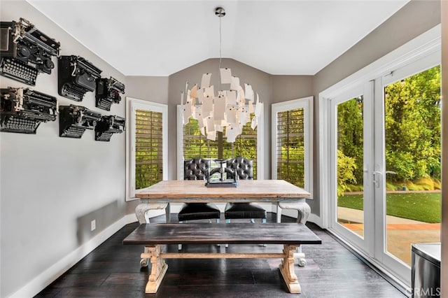 dining area with french doors, dark hardwood / wood-style floors, an inviting chandelier, and vaulted ceiling