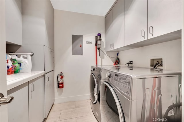 laundry room featuring cabinets, electric panel, and washer and dryer