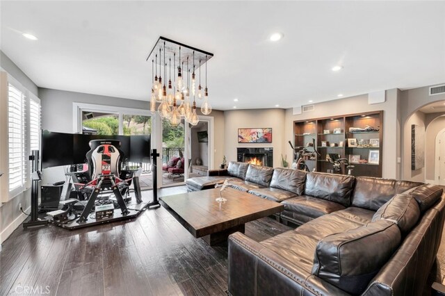 22544 N Summit Ridge Cir, Chatsworth, CA 91311 - living room featuring arched walkways, a lit fireplace, dark wood finished floors, recessed lighting, and a chandelier