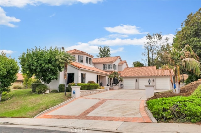 mediterranean / spanish house with a garage and a front lawn