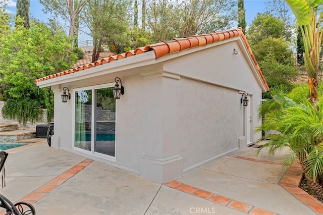 22544 N Summit Ridge Cir, Chatsworth, CA 91311 - view of side of home with a patio area, a tiled roof, and stucco siding