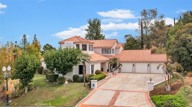 mediterranean / spanish-style home featuring a garage and a front lawn