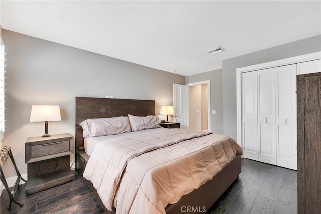 bedroom with dark hardwood / wood-style floors and a closet