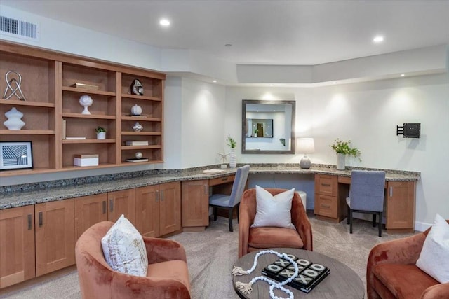 interior space featuring built in desk and light colored carpet