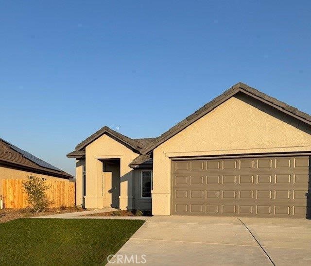 ranch-style home featuring a garage and a front lawn