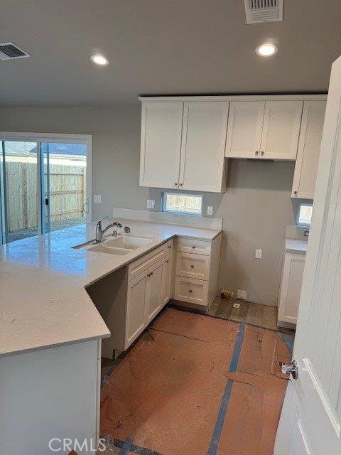 kitchen featuring white cabinetry, sink, and kitchen peninsula