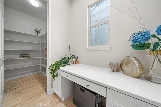 office area with built in desk and light hardwood / wood-style floors